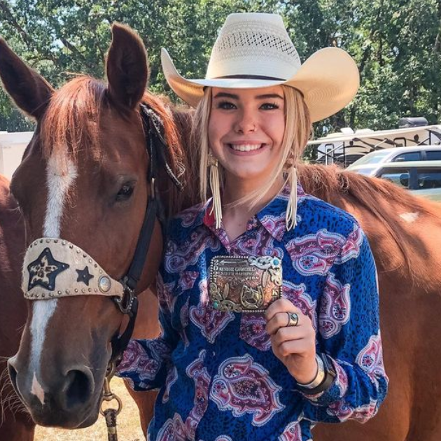 Woman with rodeo belt buckle and her horse 